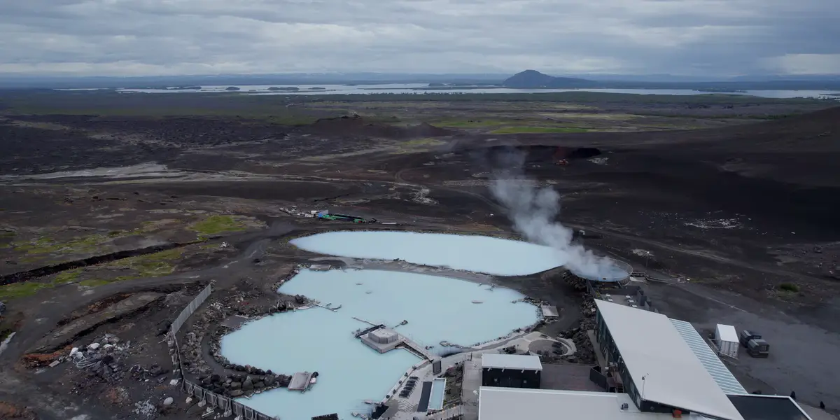Vue aérienne des bains naturels de Mývatn en Islande, entourés d’un paysage volcanique avec des eaux géothermales bleu laiteux. Un arrêt parfait pour se détendre lors d’un road trip en camping-car.