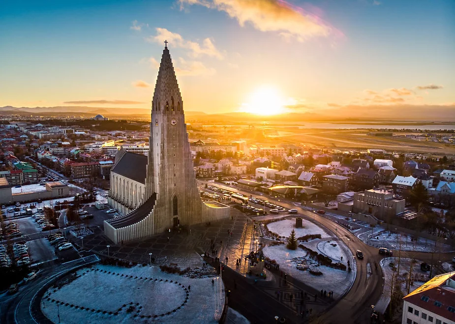 Vue par drone de la ville de Reykjavik au coucher du soleil lors d'une journée hivernale en raison de la neige entourant l'église Hallgrímskirkja.